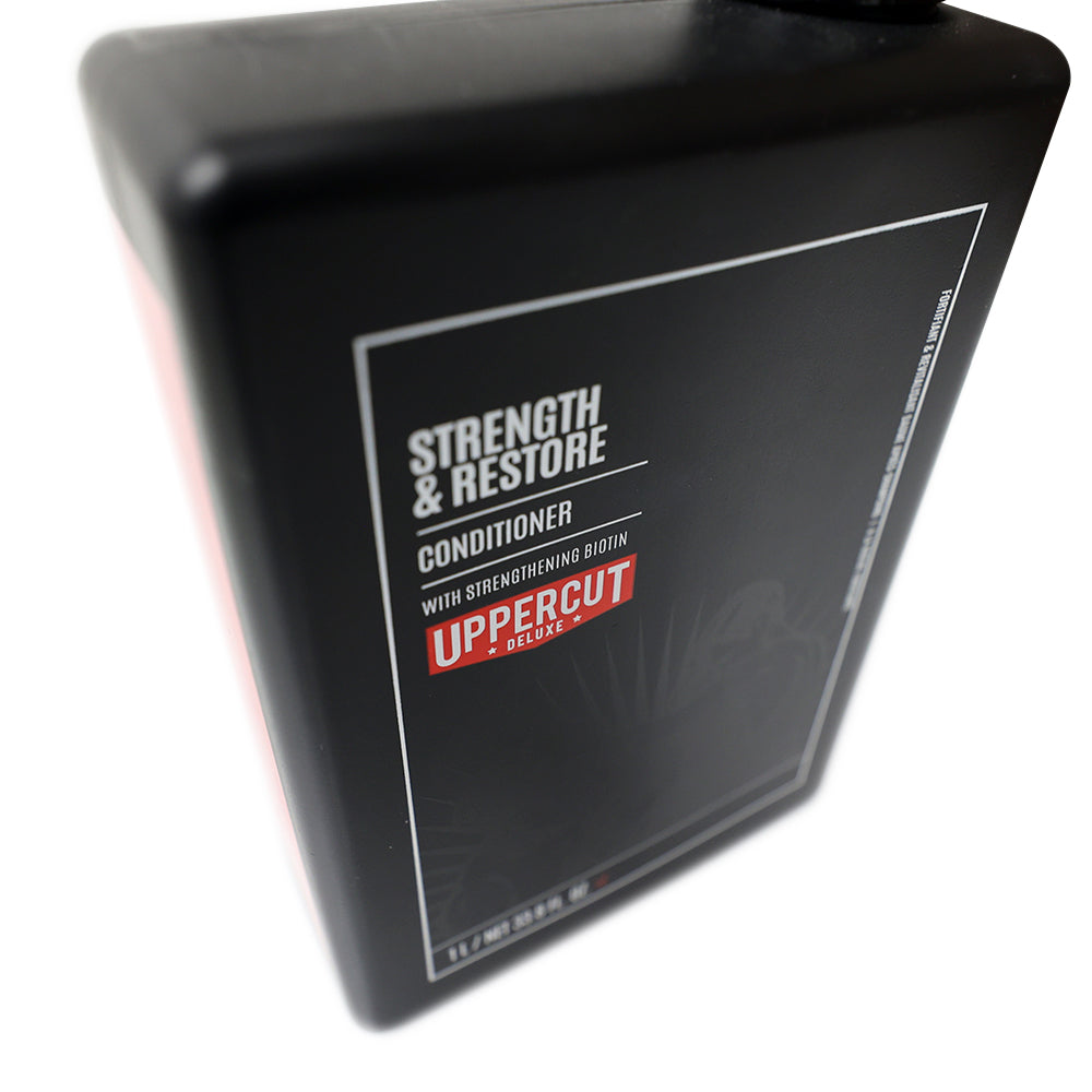 Uppercut Deluxe Strength & Restore Conditioner — 1 L bottle angled, showing the pump head