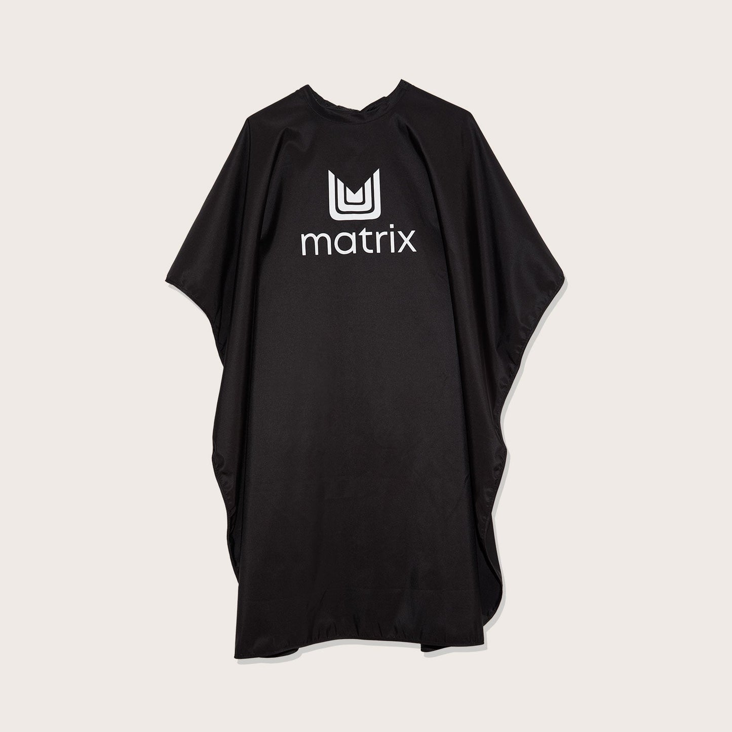 Matrix Cutting Cape — full-length matte black salon cutting cape with the Matrix logo at the chest, laid flat on a plain background