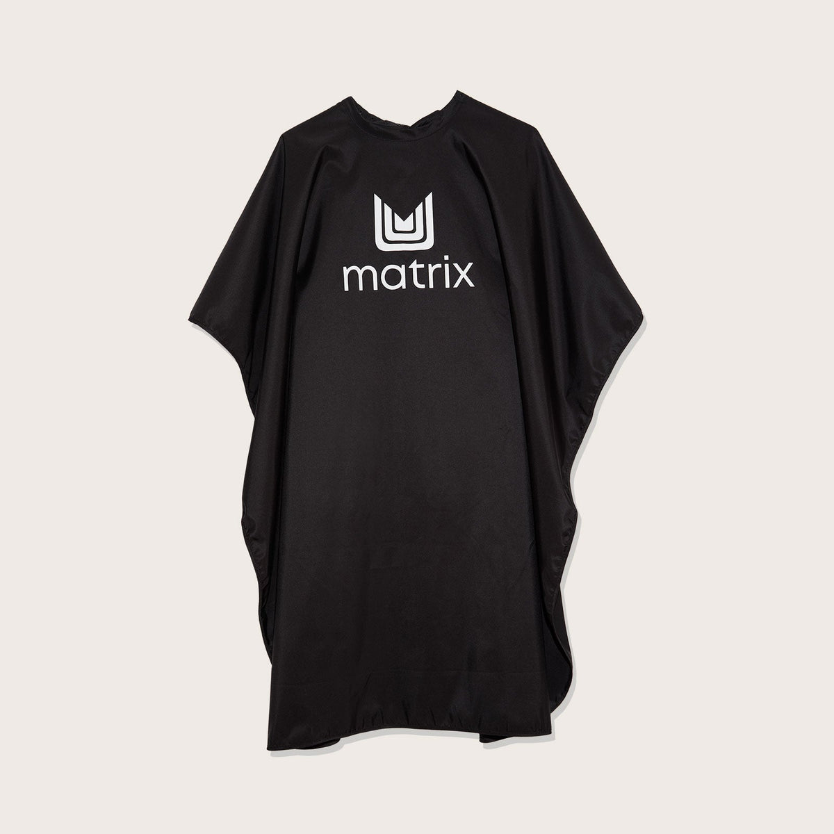 Matrix Cutting Cape — full-length matte black salon cutting cape with the Matrix logo at the chest, laid flat on a plain background