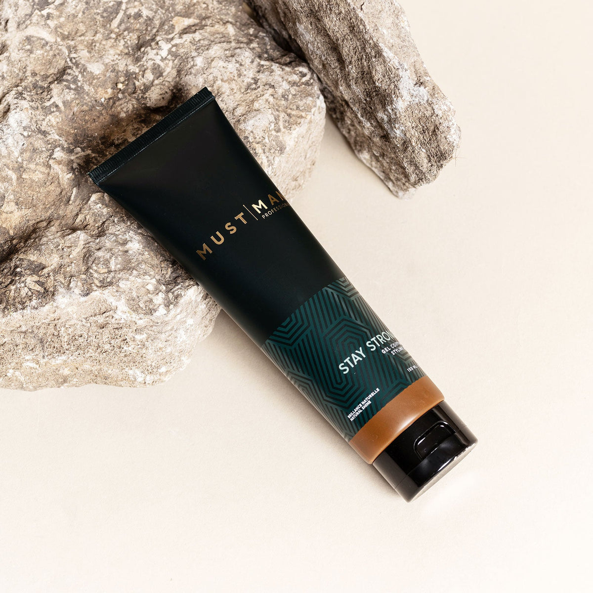 Must Man Professional Stay Strong Styling Gel — 150 ml tube tilted on a warm neutral background