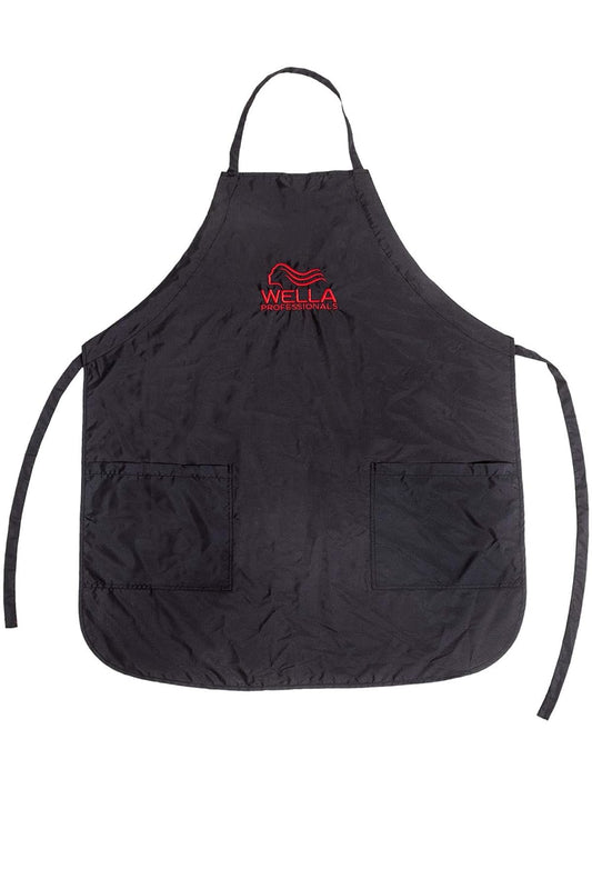 Wella Professionals Salon Apron — black water-repellent colour apron with red Wella Professionals logo and two front pockets, laid flat on white