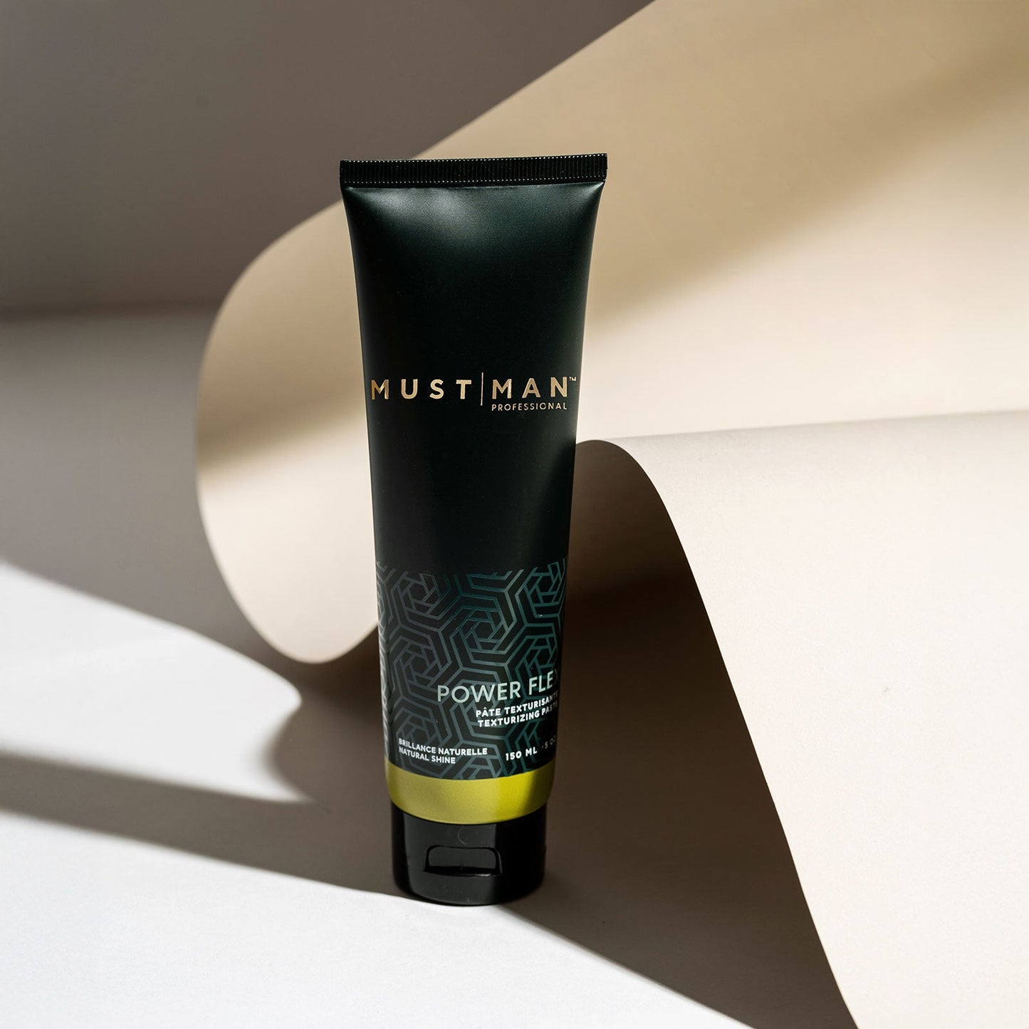 Must Man Professional Power Flex Texturizing Paste — 150 ml tube tilted on a warm neutral background