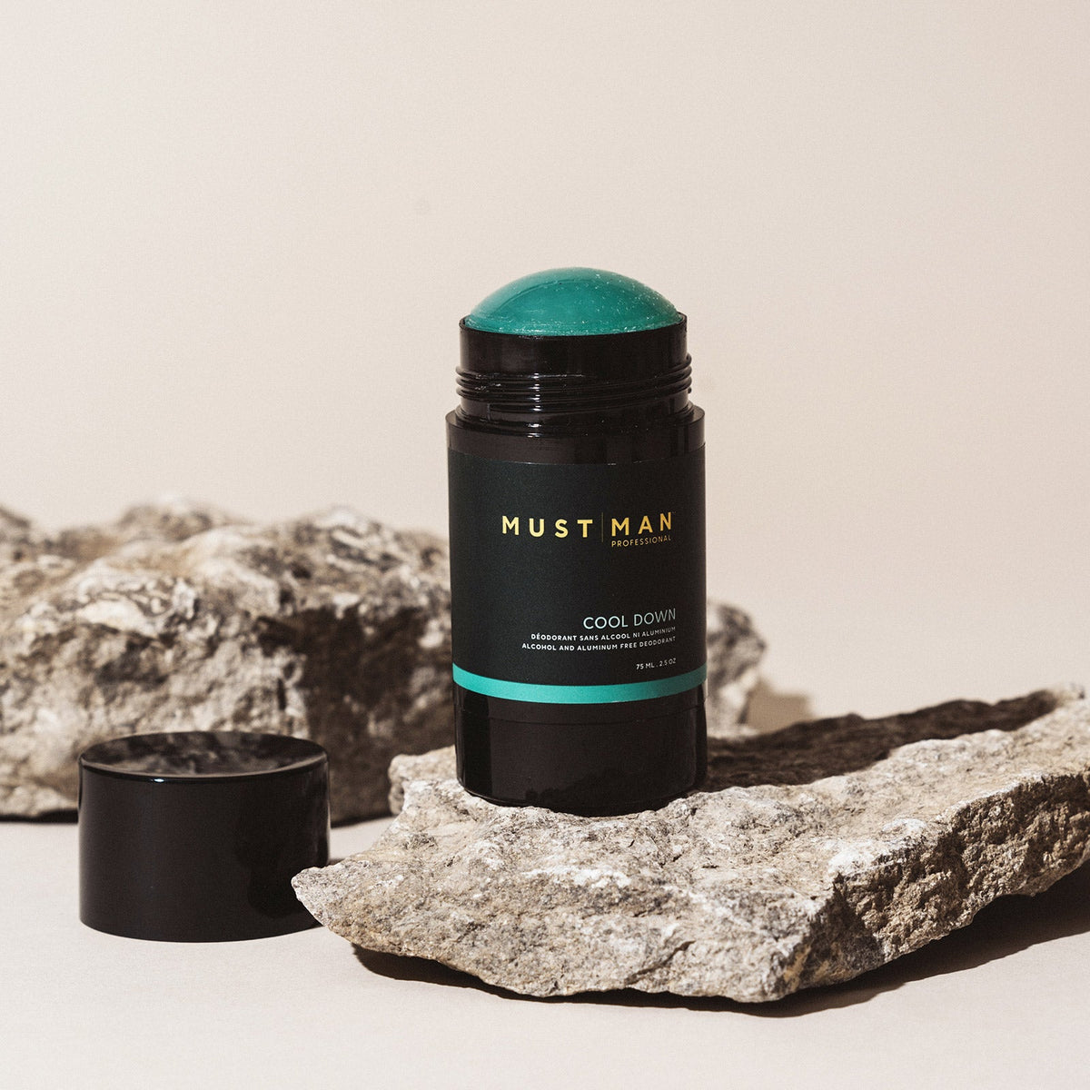 Must Man Professional Cool Down Deodorant — 75 ml deodorant stick open on stone, showing the teal balm, lifestyle shot