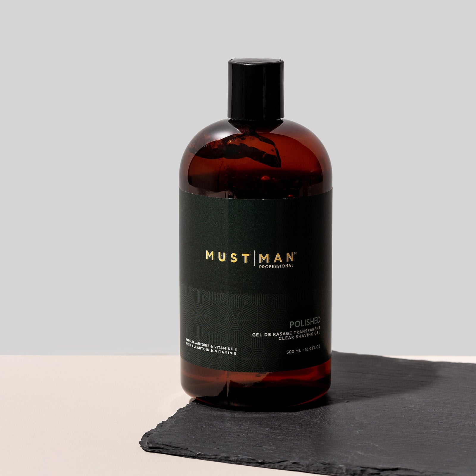 Must Man Professional Polished Clear Shaving Gel — 500 ml amber bottle standing on a slate tile, lifestyle shot