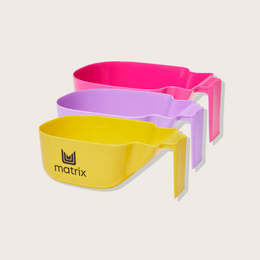 Matrix Color Bowl — three handled plastic salon tint mixing bowls in pink, lilac and yellow, stacked on a plain background to show the assorted colours supplied