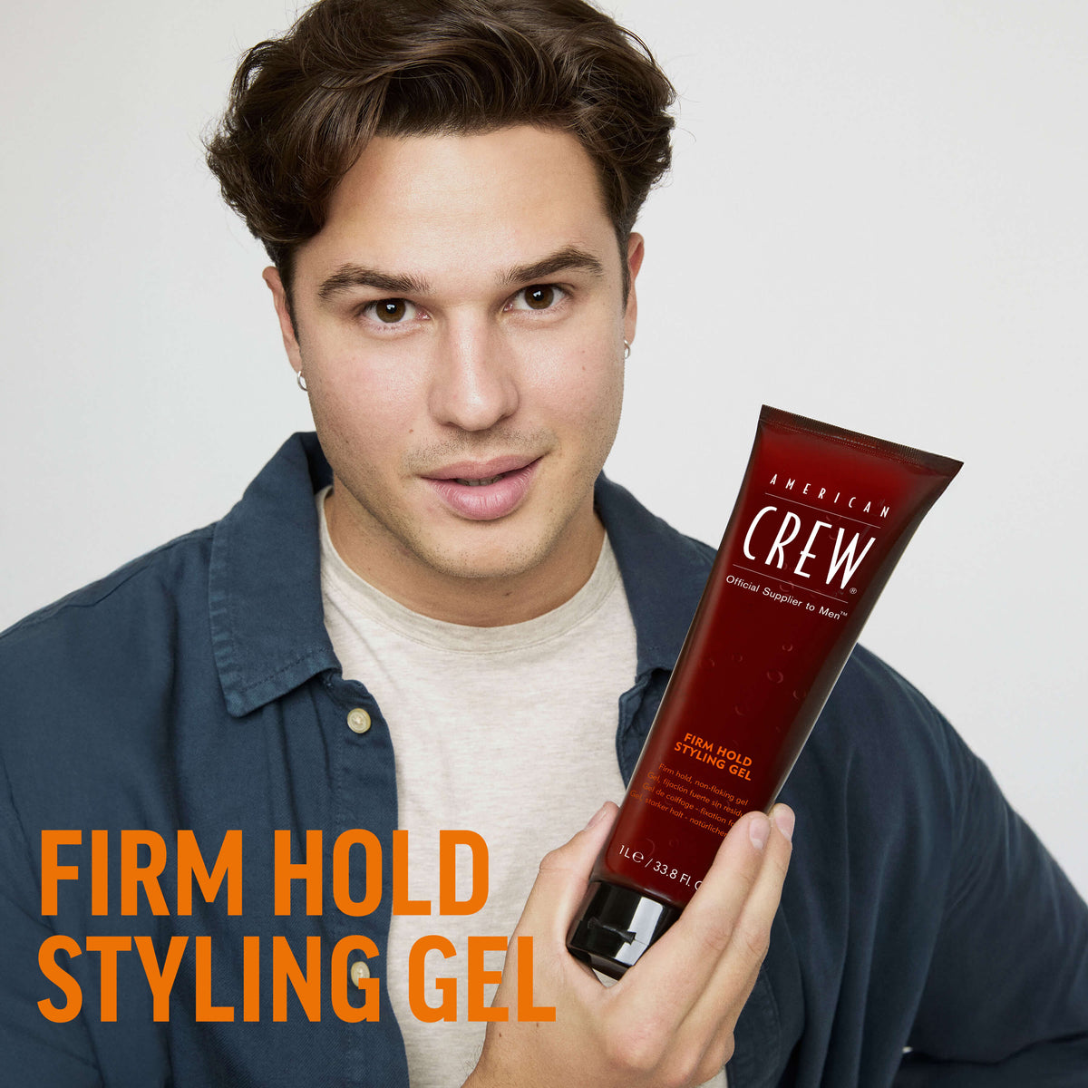 American Crew Firm Hold Styling Gel — model holding the 1 L tube, front label reading 1L / 33.8 Fl. Oz.