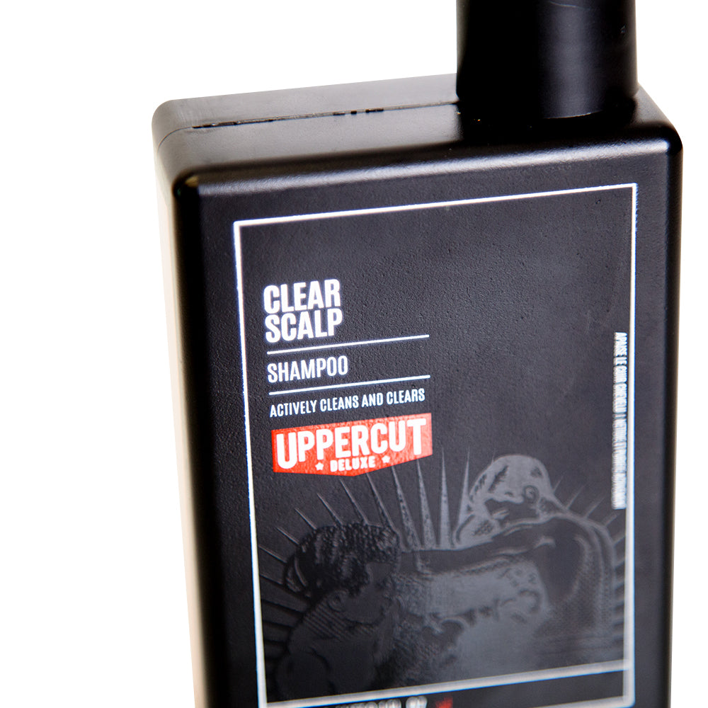Uppercut Deluxe Clear Scalp Shampoo 240 ml — black 240 ml shampoo bottle angled, front label in close-up