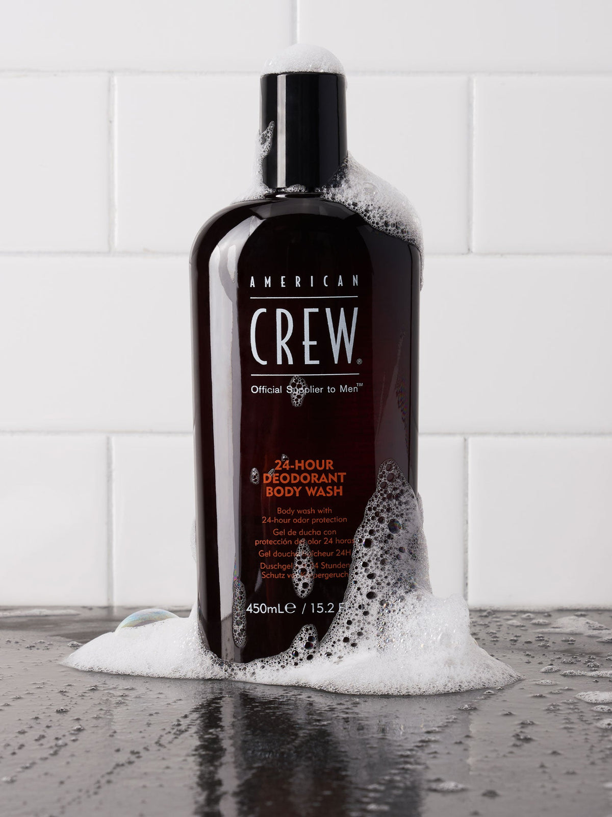 American Crew 24-Hour Deodorant Body Wash bottle in a shower setting