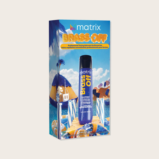 Matrix Brass Off Holiday Kit 2026 — blue candy-landscape gift carton with the blue Brass Off bottle standing in front of it