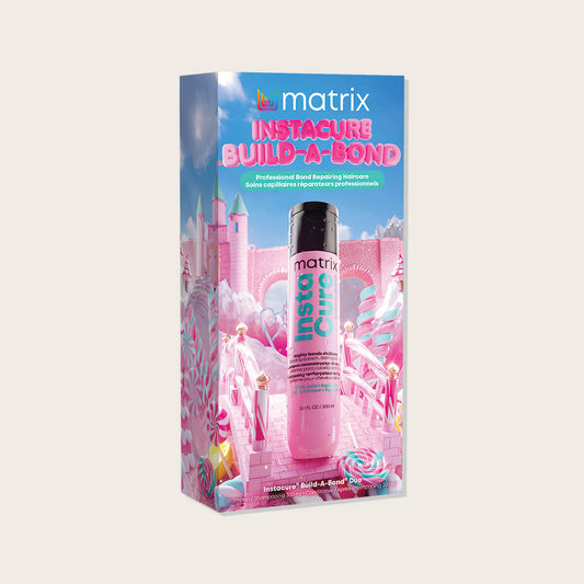 Matrix Instacure Build-A-Bond Holiday Kit 2026 — pink candy-castle gift carton with the pink Instacure bottle standing in front of it