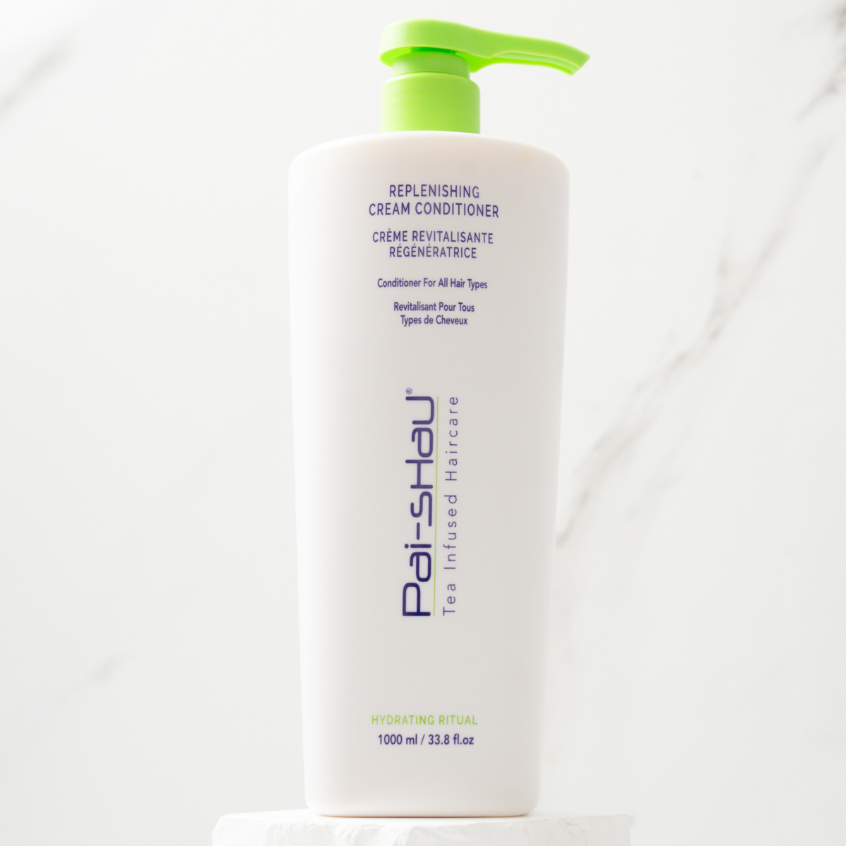 Pai-Shau Replenishing Cream Conditioner 1 L pump bottle on a marble plinth