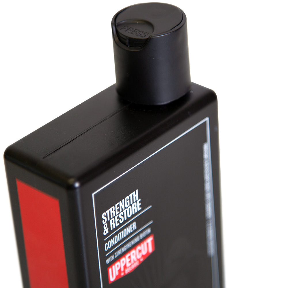Uppercut Deluxe Strength & Restore Conditioner — 240 ml bottle cap and shoulder close-up