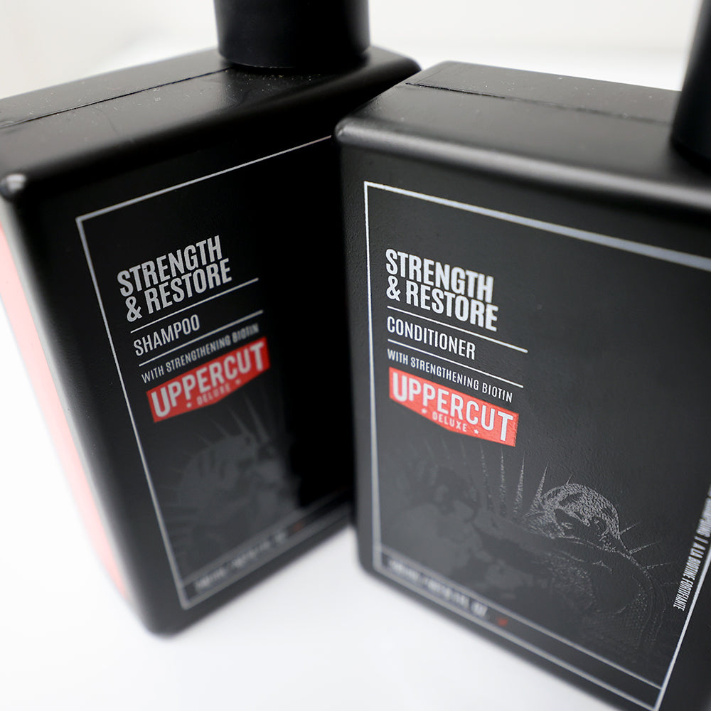 Uppercut Deluxe Strength & Restore Duo — the shampoo and conditioner bottles angled together, label detail