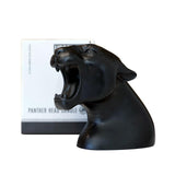 Uppercut Deluxe Panther Head Candle — black panther head candle in front of its printed card, plain white background