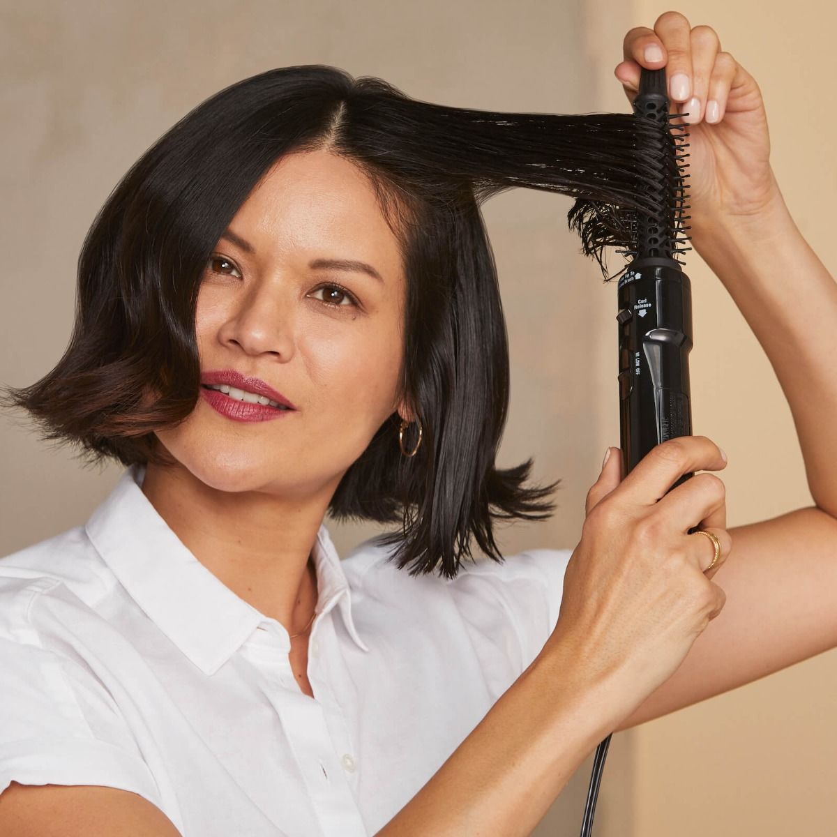 Hot Tools Professional Hot Air Brush in use — curl-release lever and HI/LOW/OFF heat switch visible