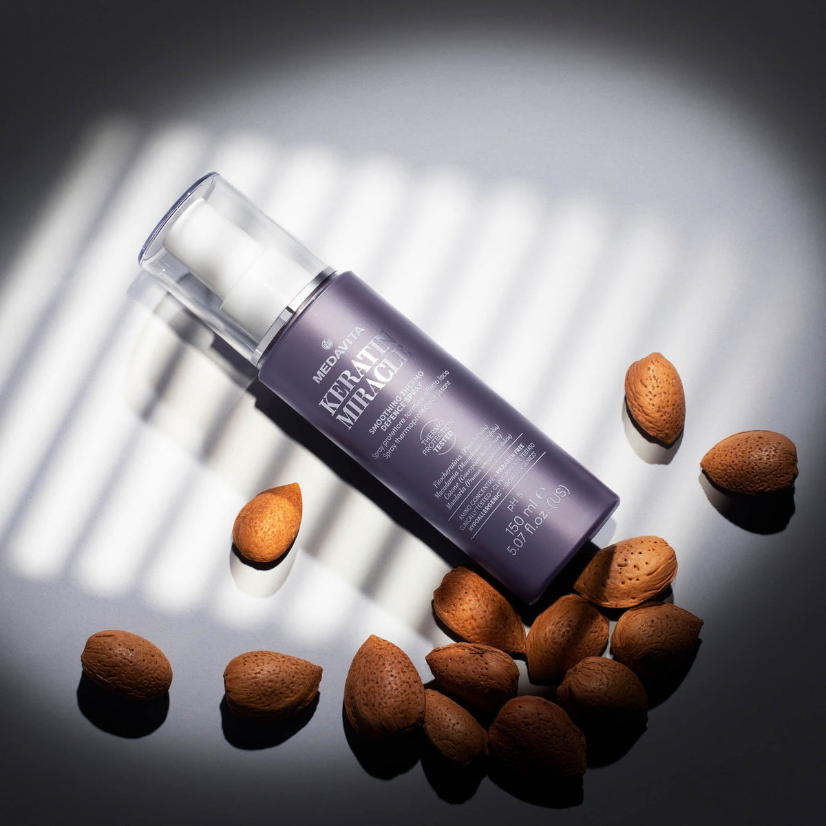 Medavita Keratin Miracle Smoothing Thermo Defence Spray — 150 ml bottle styled with almonds