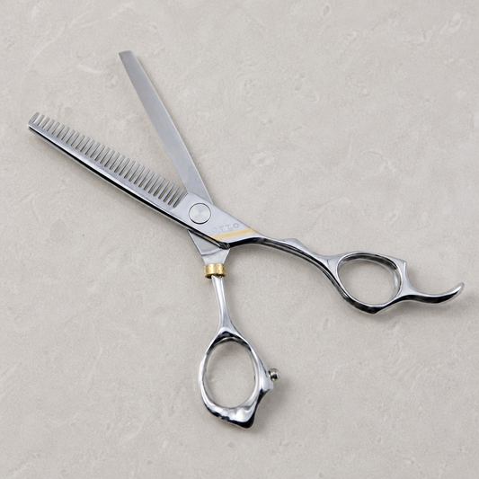 Otto 6-inch Texturizing & Thinning Shears — the thinning shear laid open on a light stone salon surface
