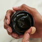 American Crew Pomade — open tub held in hand showing the glossy pomade texture