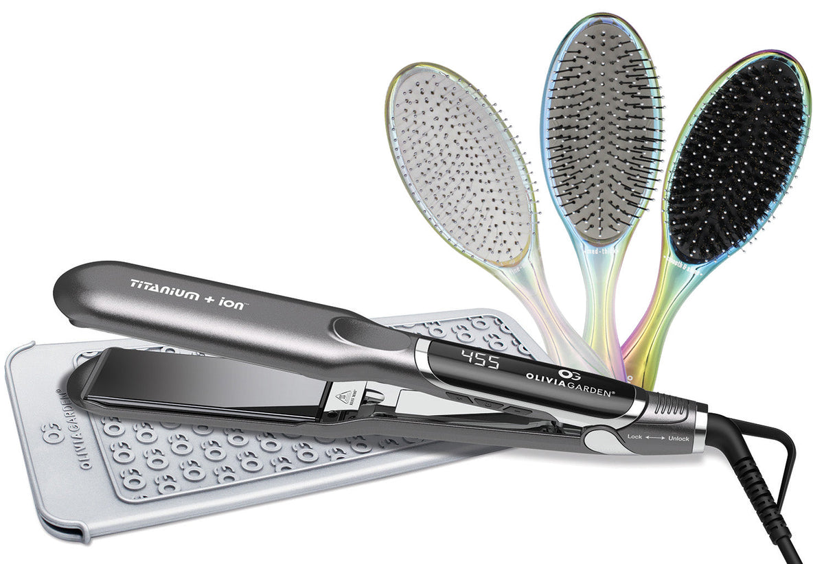 Olivia Garden Flat Iron — black and silver Titanium + Ion flat iron showing 455 on its display, resting on a silver dotted heat-resistant mat, with three iridescent oval Olivia Garden brushes fanned behind it, plain white background